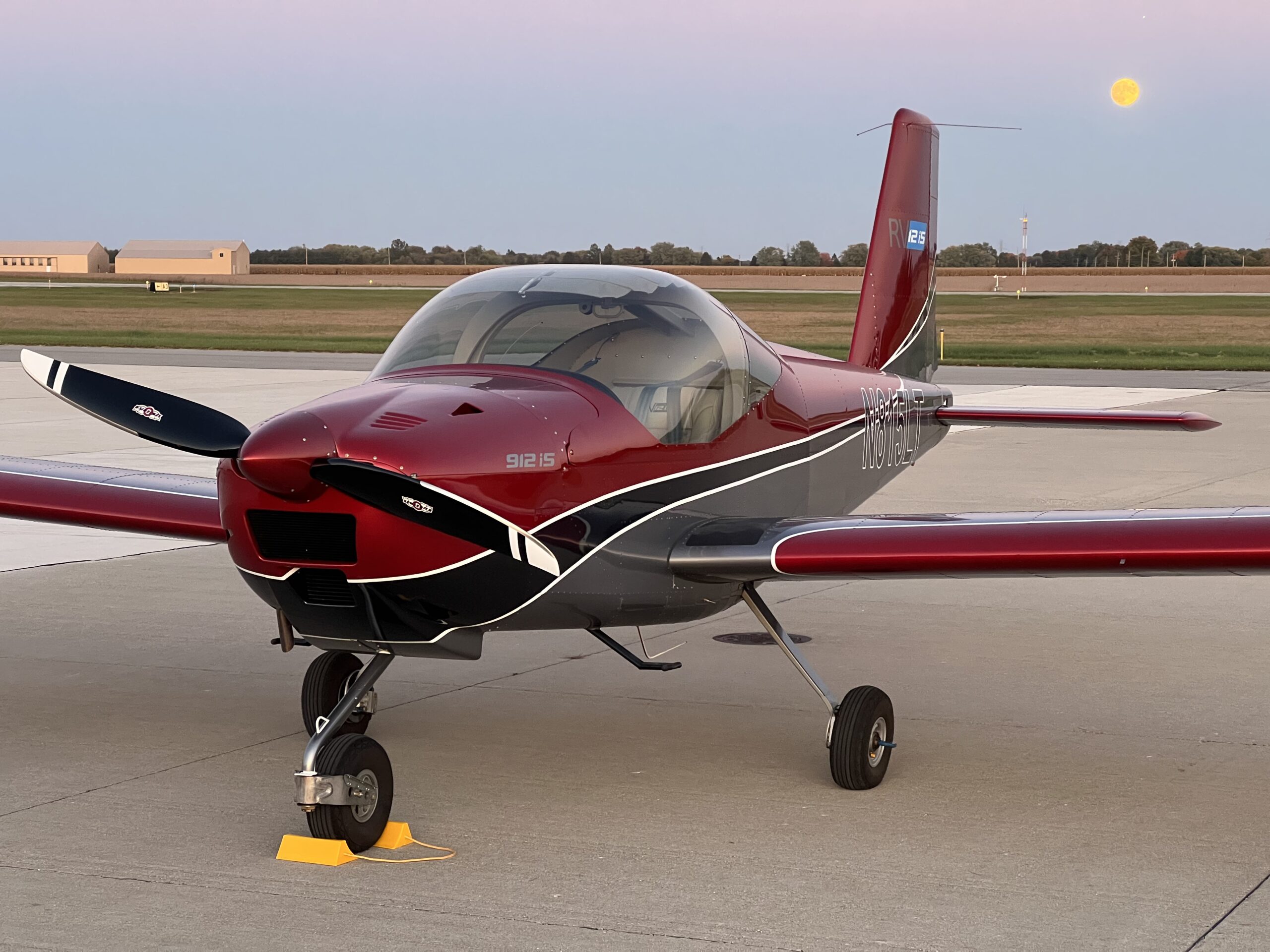 Red and gray small aircraft parked on the ramp at dusk in Northwest Indiana